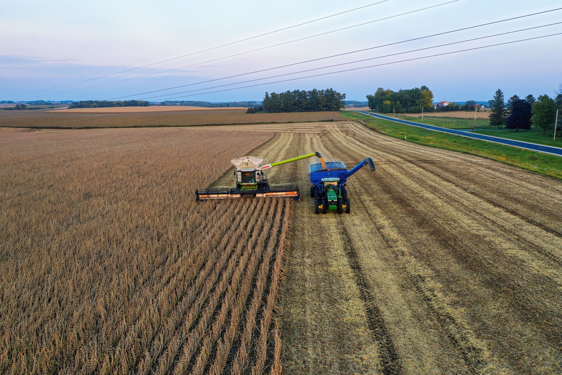 Header unloading into a chaser bin at harvest